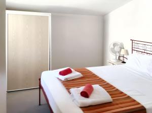 una camera da letto bianca con due asciugamani su un letto di Maison charmante à Gallargues-le-Montueux avec piscine partagée a Gallargues-le-Montueux Altre 11 foto