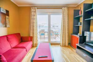 a living room with a red couch and a large window at Modern apartment in Roquetas de Mar with sea view in Roquetas de Mar