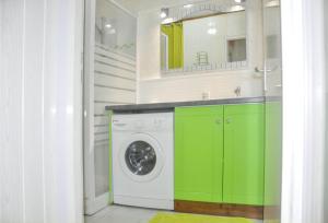 Un lavadero con armarios verdes y una lavadora. en Bungalow confortable avec vue mer à Bouillante, en Bouillante 29 fotos más