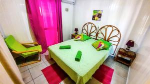 Habitación con 1 cama con mesa verde y sillas en Bungalow confortable avec vue mer à Bouillante, en Bouillante
