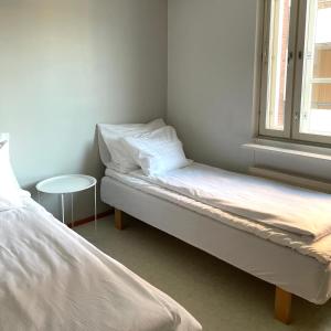 a small room with two beds and a window at Henniina V Isokatu - Sauna & Free Parking in Oulu