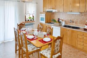 een keuken met een houten tafel met stoelen en een eetkamer bij Spacious Apartment in Klis + Balcony in Klis