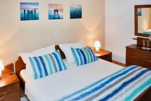 een slaapkamer met een bed met blauwe en witte kussens bij Spacious Apartment in Klis + Balcony in Klis