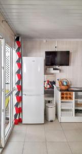 a kitchen with a white refrigerator in a room at Bungalow charmant à Bouillante avec terrasse privée in Mathurin Noël