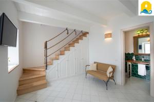 a living room with a staircase and a chair at Casa Angelie in Praiano