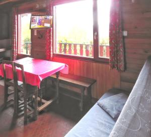 a room with a table and a bench and a window at Chalet charmant au Tholy avec piscine partagée in Le Tholy