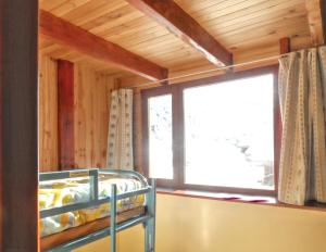 a bedroom with a bunk bed and a window at Chalet charmant au Tholy avec piscine partagée in Le Tholy