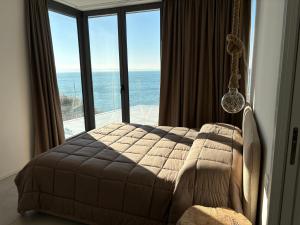 a bedroom with a bed with a view of the ocean at Seaside Resort in Trieste