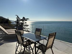 a table and chairs on a patio with the ocean at Seaside Resort in Trieste