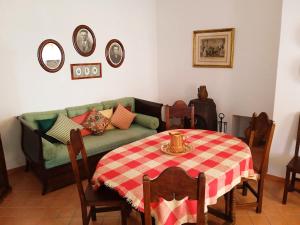 un soggiorno con un divano verde e un tavolo di Rustic Village House for Nature & Trekking Lovers a Furnazinhas Altre 9 foto
