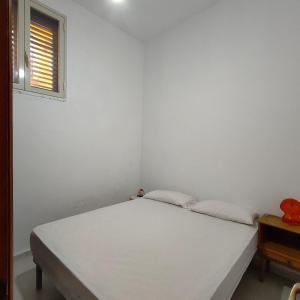 a bedroom with a white bed and a window at Appartamento di Lorenzo vista Mare in Malfa