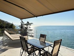 a table and chairs on a patio with a view of the ocean at Seaside Resort in Trieste