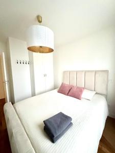 a white bed with a pillow on top of it at Très bel appartement proche Disney Paris in Les Pavillons-sous-Bois +12 photos