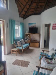 a living room with a couch and a tv at Hibberdene Cottage Crew in Hibberdene