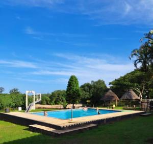 a pool at a resort with people in it at Hibberdene Cottage Crew in Hibberdene