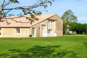 a brick house with a large grass yard at Maison de charme avec piscine et jardin à Saint-Vincent-la-Châtre in Saint-Vincent-la-Châtre