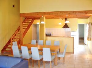 a dining room with a wooden table and white chairs at Maison de charme avec piscine et jardin à Saint-Vincent-la-Châtre in Saint-Vincent-la-Châtre