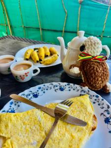 a table with a plate of omelet and a plate of food at Marari Red Angel in Mararikulam
