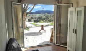 a sliding glass door leading to a patio with a table at Maison charmante avec piscine privée à Orthoux-Sérignac-Quilhan in Bragassargues