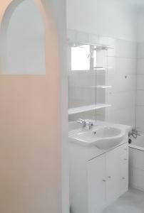 a white bathroom with a sink and a mirror at Maison charmante avec piscine privée à Orthoux-Sérignac-Quilhan in Bragassargues