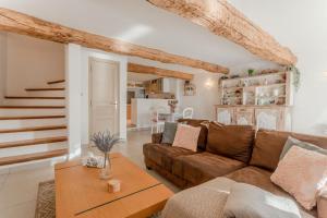 a living room with a brown couch and a table at Maison Sainte Maxime in Le Plan