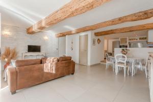 un soggiorno con un divano marrone e un tavolo di Maison Sainte Maxime a Le Plan