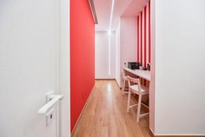 a room with a red accent wall and a table at City Rooms 74 in Salerno