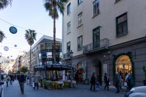 a group of people walking down a city street at City Rooms 74 in Salerno