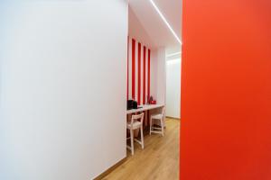 a room with a table and a red wall at City Rooms 74 in Salerno