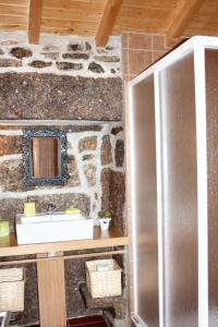 une salle de bain avec un lavabo et un mur en pierre dans l'établissement Spacious Family House in Nogueira with Garden, à Moita