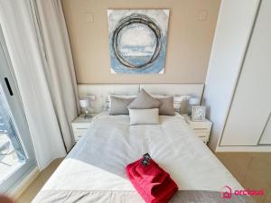 a bedroom with a white bed with a red towel on it at Brisa Azul in Cabanes