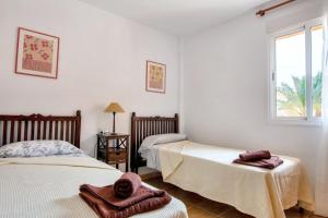 sypialnia z dwoma łóżkami i oknem w obiekcie Seaside Apartment in Mojácar + Pool w mieście Mojácar +18 zdjęć