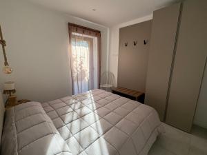 a white bedroom with a bed and a window at Seaside Resort in Trieste