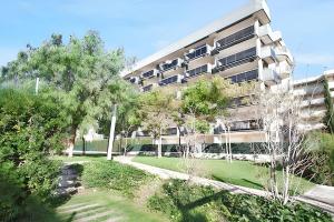 an apartment building with a lawn in front of it at Comfortable apartment in Platja de la Pineda 70 m² with pool in La Pineda
