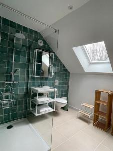 a bathroom with a sink and a toilet and a skylight at Gîte les 2 cygnes à Briare dans le Loiret in Briare
