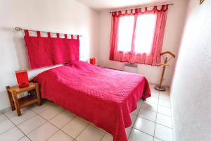 a bedroom with a red bed and a window at Charmante maison à Argelès-sur-Mer avec vue sur montagne in Argelès-sur-Mer
