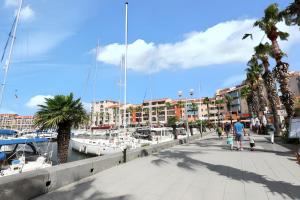 a man and a child walking on a sidewalk near a marina at Charmante maison à Argelès-sur-Mer avec vue sur montagne in Argelès-sur-Mer +5 photos