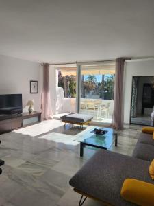 a living room with a couch and a tv at LAALCAZABA Garden in Marbella