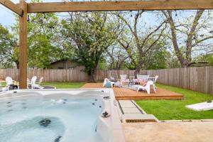 - un bain à remous dans la cour avec une table et des chaises dans l'établissement Pink Duchess - Mins to Main Hot Tub & Fire Pit, à Fredericksburg