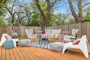 une terrasse avec des chaises et des tables et une clôture dans l'établissement Pink Duchess - Mins to Main Hot Tub & Fire Pit, à Fredericksburg
