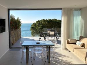 a living room with a table and a view of the ocean at Seaside Resort in Trieste