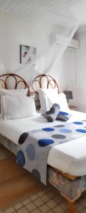 a bedroom with two beds with white and blue comforter at Bungalow accueillant à Bouillante avec climatisation et terrasse in Bouillante