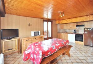 una cocina con mesa y TV. en Appartement confortable à La Chapelle-d'Abondance 75 m² avec jardin, en La Chapelle-dʼAbondance