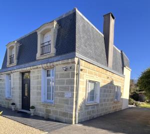 an old stone house with a black roof at Les Suites d'Aliénor, Suite Jasmin in Pessac