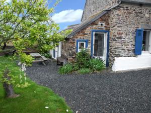 a stone house with a blue door and a bench at Maison charmante à Pordic, cheminées et jardin clos in Pordic