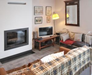 a living room with a couch and a flat screen tv at Maison charmante à Pordic, cheminées et jardin clos in Pordic