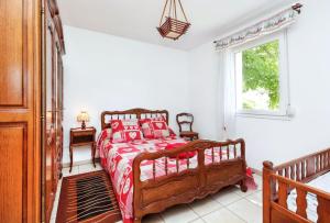 a bedroom with a wooden bed with red pillows at Maison spacieuse près de Gérardmer avec vue sur le lac in Gérardmer