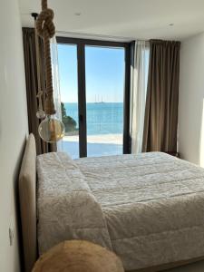 a bedroom with a bed with a view of the ocean at Seaside Resort in Trieste