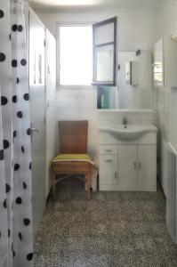 a bathroom with a chair and a sink and a window at Maison accueillante à Orgnac-l'Aven avec piscine partagée in Orgnac-lʼAven