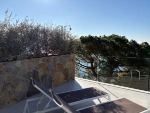 a table and chairs on a roof with trees at Seaside Resort in Trieste